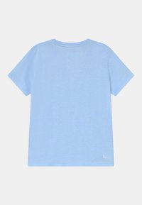 T-shirt à manches courtes bleu clair avec un col rond, texture douce et logo "Ultra Dry" sur le bas. Design simple, sans motifs.
