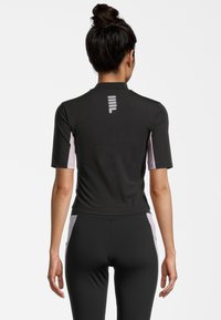 Černé sportovní tričko s krátkými rukávy a růžovými akcenty na bocích, úzký střih, hladká textura a reflexní logo na zádech.