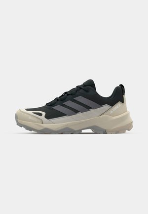 Men's black and gray trail running shoes with a GORE-TEX upper, rugged sole, and textured details for traction and durability.