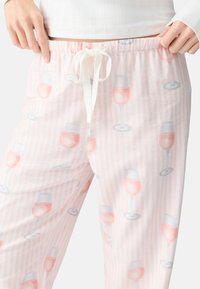 Pantaloni da pigiama a righe rosa e bianche in tessuto morbido, caratterizzati da un motivo di bicchieri da vino illustrati. Vita elastica con coulisse.