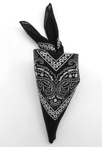 Bandana noire avec un motif paisley blanc, agrémenté de motifs et d'accents complexes. Tissu léger, de forme triangulaire avec des extrémités nouées.