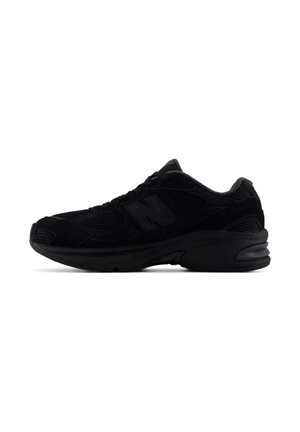 Schwarzer sportlicher Sneaker mit Mesh- und Wildleder-Obermaterial, dicker Sohle und Schnürdesign, von der Seite auf weißem Hintergrund gesehen.
