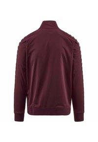 Giacca sportiva bordeaux con colletto alto, polsini a costine e una texture liscia. Presenta strisce laterali con un motivo a logo ripetuto.