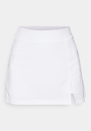Fehér sportos szoknya könnyű anyagból, széles derékpánttal, oldalsó hasítékkal és egy kis logóval a szegélyen.