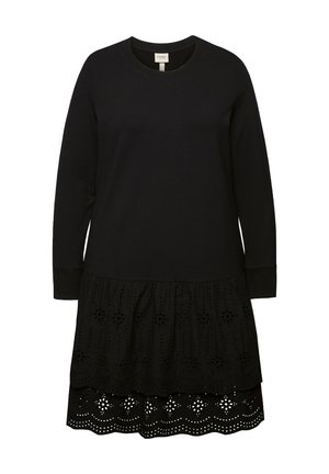 Robe noire à manches longues et col rond. Elle présente un ourlet à volants en couches avec une broderie œillets détaillée et des bords festonnés.