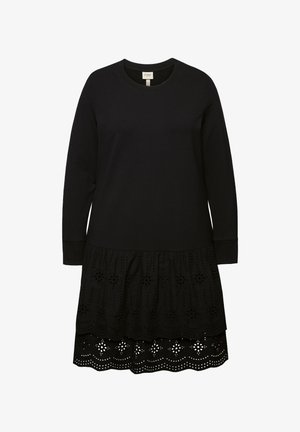 Mustapuku pitkähihaisilla ja pyöreällä kaula-aukolla. Sisältää kerroksittain kerrostetun helman, jossa on yksityiskohtainen rei'itetty brodeeraus ja aaltoilevat reunat.