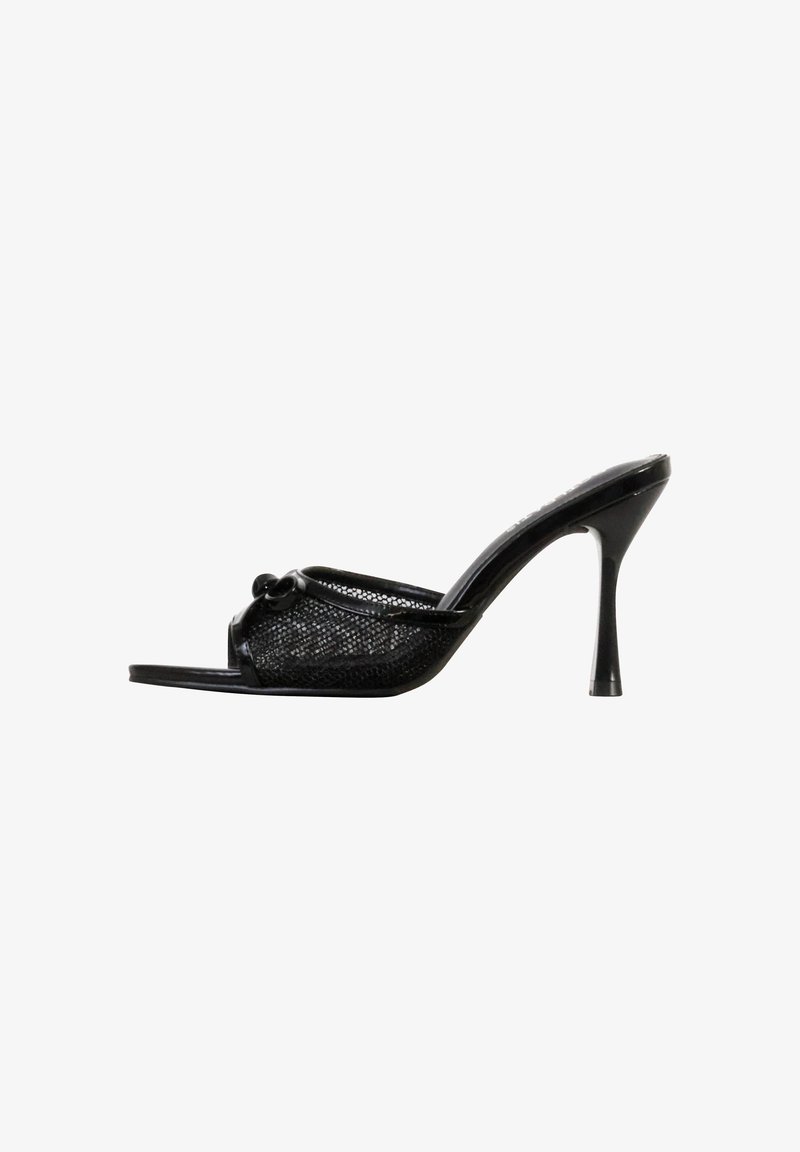 Mule noire à talons hauts ouverte à l'avant, avec tige en mesh et détail de nœud décoratif sur fond blanc.