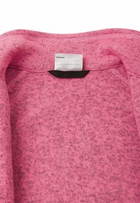 Rosa Kapuzenpullover aus weichem, strukturiertem Stoff. Verfügt über einen runden Ausschnitt, kontrastierende Innenkante und ein weißes Pflegeetikett innen.