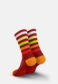 Rote gestreifte Socken mit abwechselnden Mustern in Weiß, Gelb, Grün, Orange und Rot. Einfarbige orangefarbene Akzente an Zehen und Ferse.
