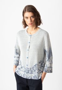 Light gray cardigan with round neckline, blue buttons, and printed blue landscape design at the hem and sleeves. Soft texture, relaxed fit.