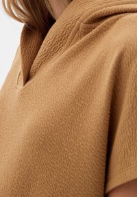 Hnědý fleece top s texturovaným povrchem, krátkými rukávy a malým límečkem ve výstřihu do V.