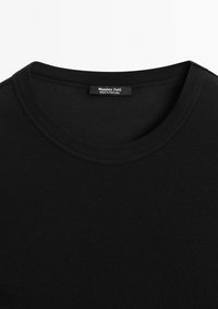 Černé bavlněné tričko s kulatým výstřihem, hladkou strukturou a krátkými rukávy. Štítek uvádí "Massimo Dutti, vyrobeno v Portugalsku."