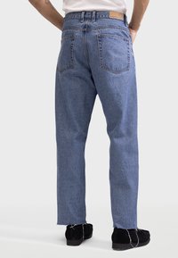 Lichtblauwe denim jeans met een relaxte pasvorm, vijf zakken en een ruwe zoom. Bevat een bruin leren label op de achterkant van de tailleband.