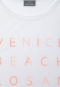 T-shirt bianca con il bold rosa "VENICE BEACH". Caratterizzata da un collo rotondo e un tessuto morbido e leggero con una texture sottile.