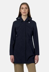 Donkerblauwe waterdichte jas met een capuchon, een rits aan de voorkant, zijzakken, een slanke silhouette en een klein logo op de borst.