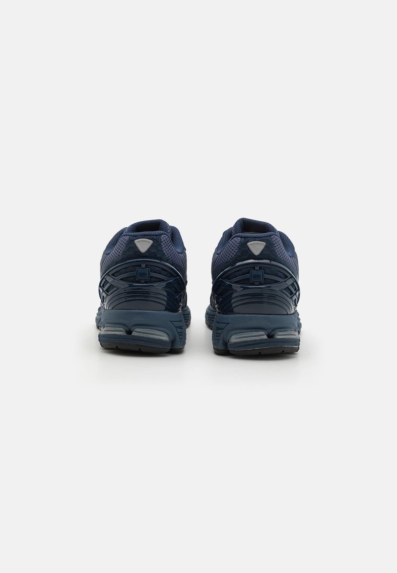Baskets de sport bleu marine avec une tige en mesh, une semelle rembourrée et un design épuré avec une finition texturée. Comprend des accents réfléchissants.