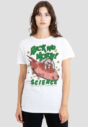 Young woman wearing a white Rick and Morty T-shirt with characters in a spaceship and green text reading "SCIENCE" on a plain background.