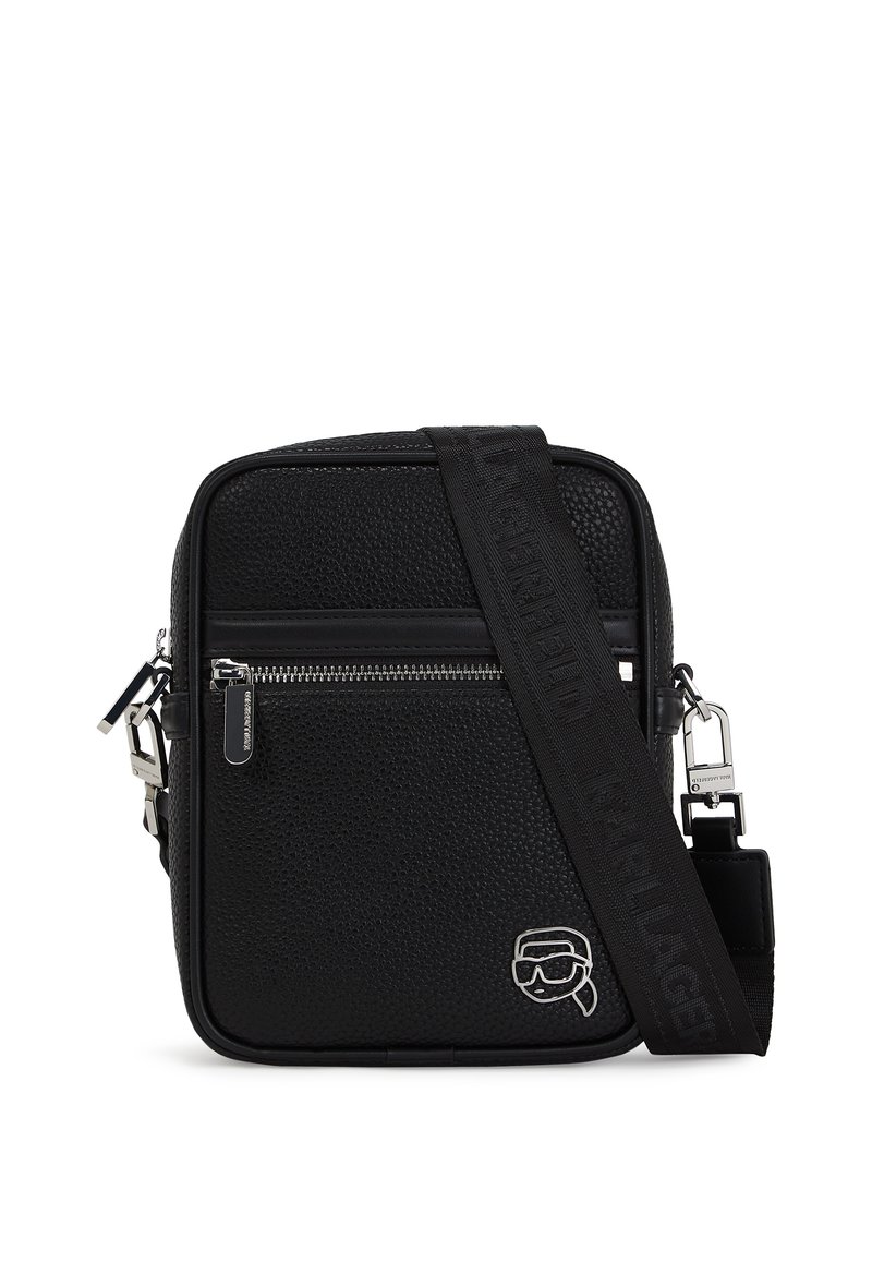 Zwarte textuur crossbodytas met een ritsluiting, verstelbare schouderband en zilveren hardware. Heeft een logo-detail aan de voorkant.
