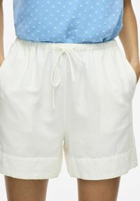 Hvide shorts med elastisk talje og snøre. Fremstillet af letvægtsstof med en glat tekstur og en afslappet pasform.