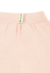 Tessuto a maglia rosa chiaro con vita a coste e una piccola etichetta verde con il logo di un orso. Texture morbida e design senza cuciture.