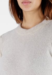 Maglione grigio chiaro a maglia con scollo rotondo, caratterizzato da un tessuto morbido e testurizzato e sottili accenti a coste nel colletto.