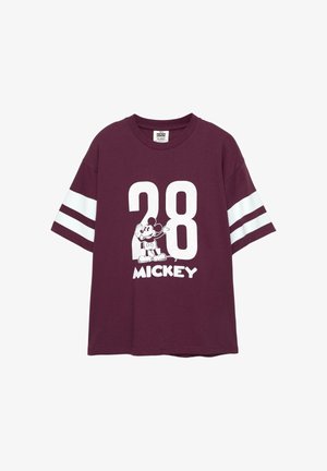 Maroonin värinen puuvillapaita, jossa on valkoiset raidalliset hihat. Paidan etuosassa on suuri numero "28" ja Mickey Hiiren grafiikka tekstin "MICKEY" kanssa.