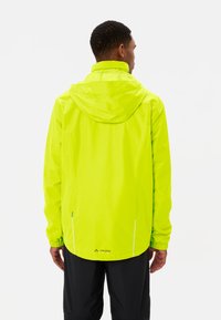 Heldere neon gele waterdichte jas met een capuchon, elastische manchetten, reflecterende accenten en een logo op de onderrug. Gladde textuur.