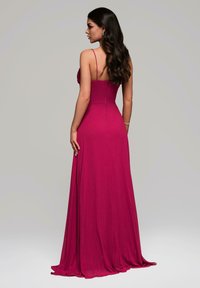 Fuchsia Abendkleid mit dünnen Spaghettiträgern, tailliertem Oberteil und fließendem Rock. Glatte Textur mit einem Reißverschlussdetail hinten.