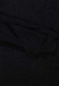 Tissu noir texturé, présentant une surface douce et duveteuse avec un éclat subtil. Le matériau semble léger et superposé, avec des bords pliés.