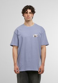 Tricou din bumbac de culoare mov deschis, cu mâneci scurte, guler rotund și un mic design grafic în zona stângă a pieptului. Textură moale, croială largă.