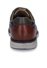 Chaussures en cuir pour homme avec une tige navy, un talon marron, des accents gris texturés et une semelle en caoutchouc blanche au fini texturé.