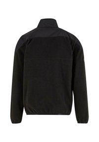 Giacca in pile nera con colletto alto, polsini elastici e pannello spalla liscio. Presenta una singola cucitura posteriore e un design ergonomico.