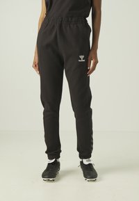 TRAVEL - Tracksuit bottoms - black