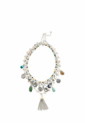 Multi-strand necklace with turquoise and brown beads, silver charms, gemstones, and a silver chain tassel pendant on white background.
