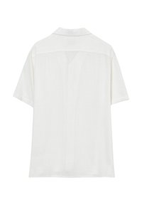Camicia bianca a maniche corte, con colletto, realizzata in tessuto leggero con finitura testurizzata. Presenta una vestibilità rilassata e un dettaglio sul yoke posteriore.