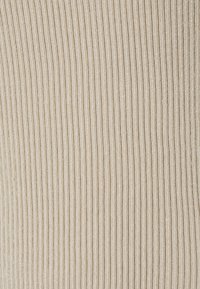 Ribbad tyg i beige med fina vertikala linjer, med en slät textur och lätt glans. Lämplig för en rad olika klädesplagg.