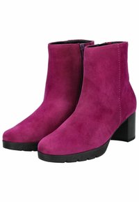 Botas ankle de ante fucsia con punta redondeada, cremallera lateral y tacón cuadrado de 7 cm, que presentan una suela de goma negra texturizada.