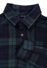 Camicia in flanella con un motivo a quadri verde scuro e blu navy, colletto abbottonato e polsini a un bottone. Tessuto morbido.