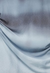 Tissu en satin bleu clair avec des plis doux et des variations subtiles d'ombre créant une texture lisse et fluide.