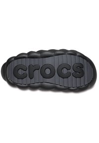 Zwarte Crocs-zool van gestructureerd grijs rubber, met een prominent "crocs" logo en ronde, gewatteerde randen voor comfort en duurzaamheid.