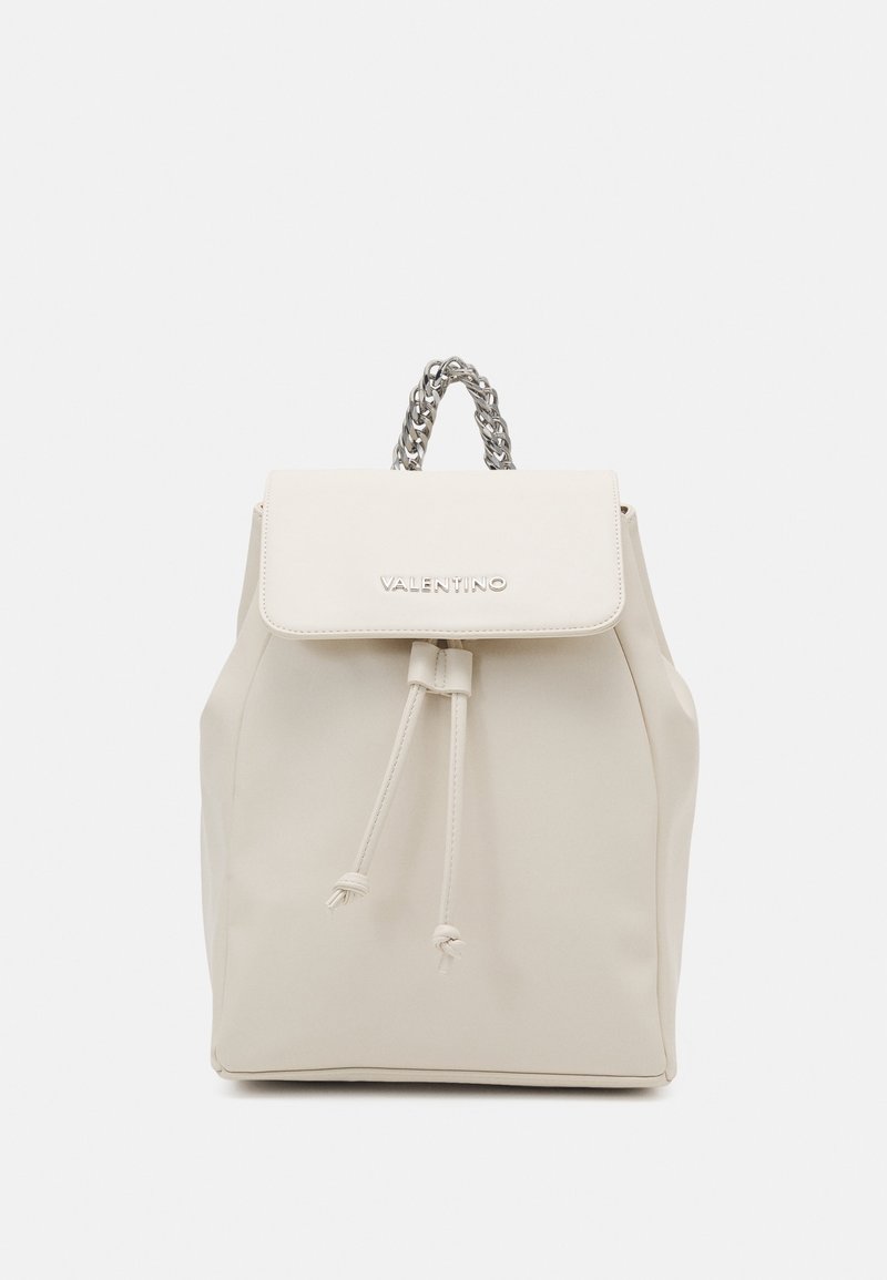 Beige Valentino ryggsäck med dragsko, klaff med logotyp och silverfärgad kedja som handtag, visad mot en vit bakgrund.