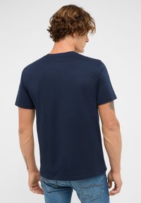 Granatowa bawełniana koszulka z krótkim rękawem, gładka w dotyku, okrągły dekolt i klasyczny krój, pokazana z tyłu.