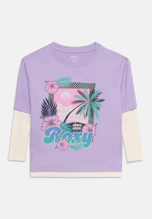Chemise manches longues violette avec manches crème superposées, imprimé floral palmier et hibiscus, bordure damier, et texte "Roxy since 1990" sur le devant.