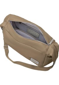 Beige polstret veske med glidelåslukking, justerbar stropp og innvendige rom. Har preget logo-patch og glatt tekstur.