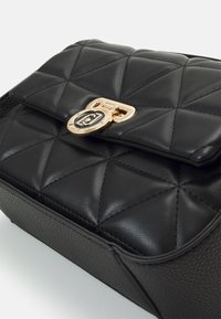 Schwarze, gesteppte Lederhandtasche mit einem goldenen Verschluss. Verfügt über einen strukturierten Boden, einen glatten oberen Deckel und eine Rautensteppung.