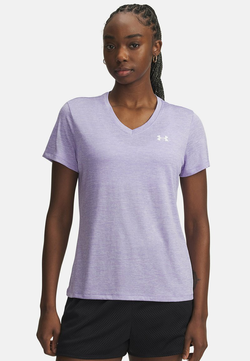 Lichtpaarse, kortemouw atletische shirt met een v-hals en subtiele textuur; heeft een wit logo op de borst; gecombineerd met zwarte shorts.
