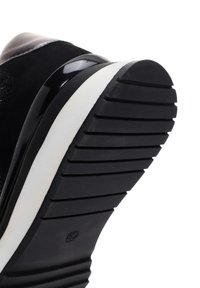Sneaker neri con una tomaia texturizzata, dettagli neri lucidi e una suola in gomma spessa e testurizzata con scanalature orizzontali.