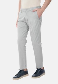 Chinos grigi chiaro realizzati in tessuto morbido, con vita piatta, tasche laterali e un design slim fit, abbinati a sneaker blu navy.