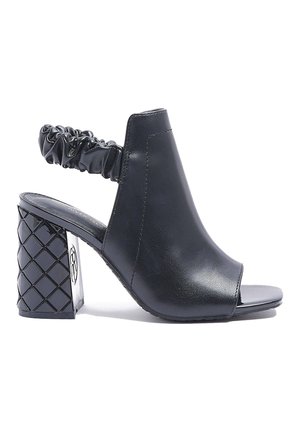 Schwarze Sandale mit offenem Zehenbereich und Absatz, aus glattem Leder, mit gerafftem Rückengurt und gemustertem Blockabsatz. Minimalistisches und modernes Design.