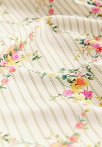 Bloemstof met roze, gele en groene bloemen op een crèmekleurige achtergrond met dunne groene strepen, zachte textuur en ingewikkelde details.